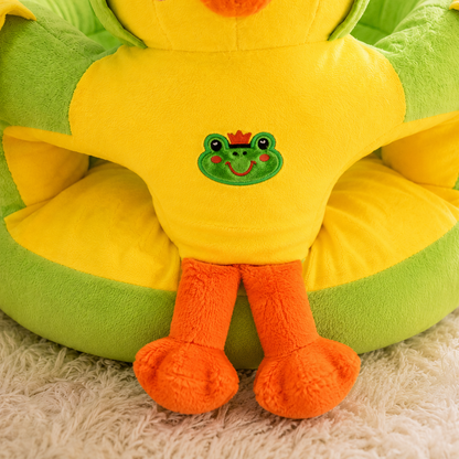 Plush toy frog with a green face and orange feet on a green and yellow cushion.